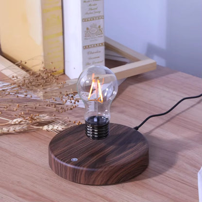 Classic light bulb magnetic levitating lamp glowing on desk with visible power cable
