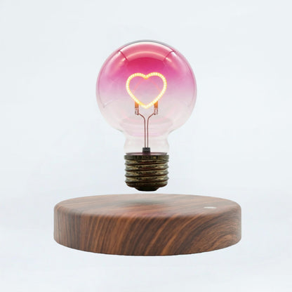 Floating heart light bulb magnetic levitating lamp on wooden base, white background