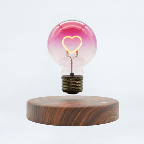Floating heart light bulb magnetic levitating lamp on wooden base, white background