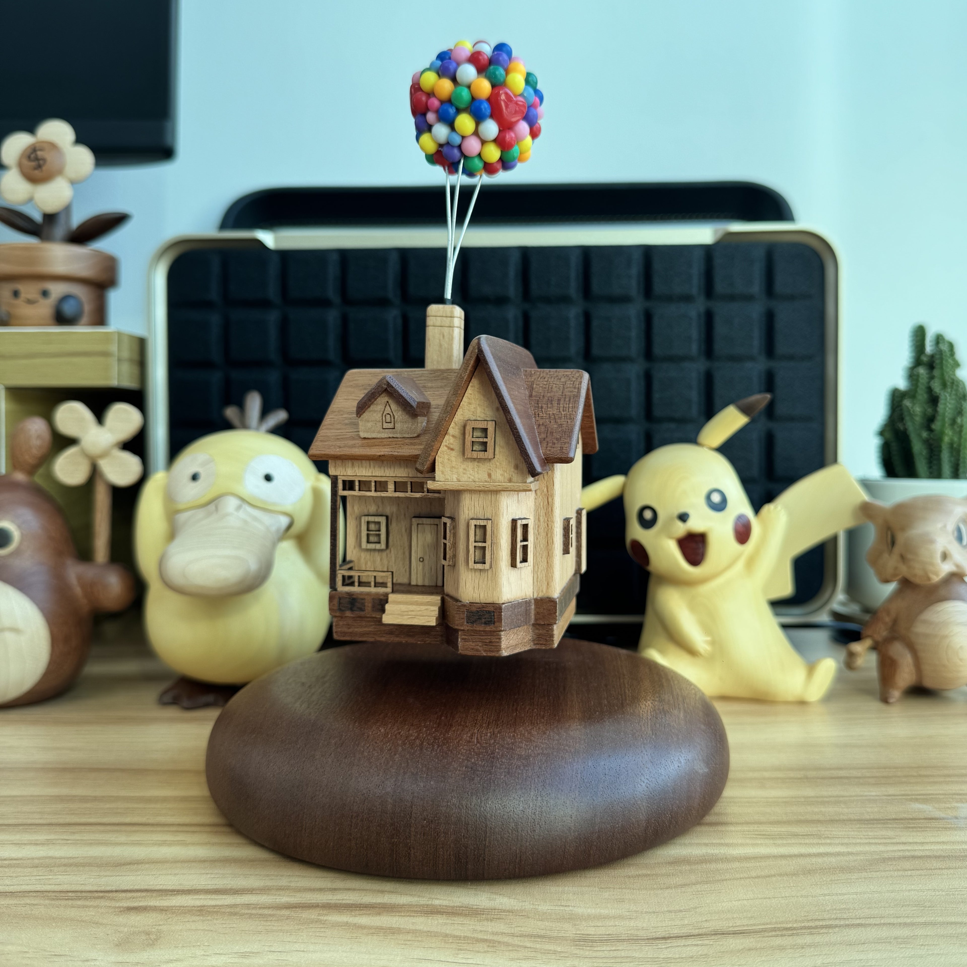 Creative levitating wooden balloon house toy with colorful balloons, unique handmade desk decor.