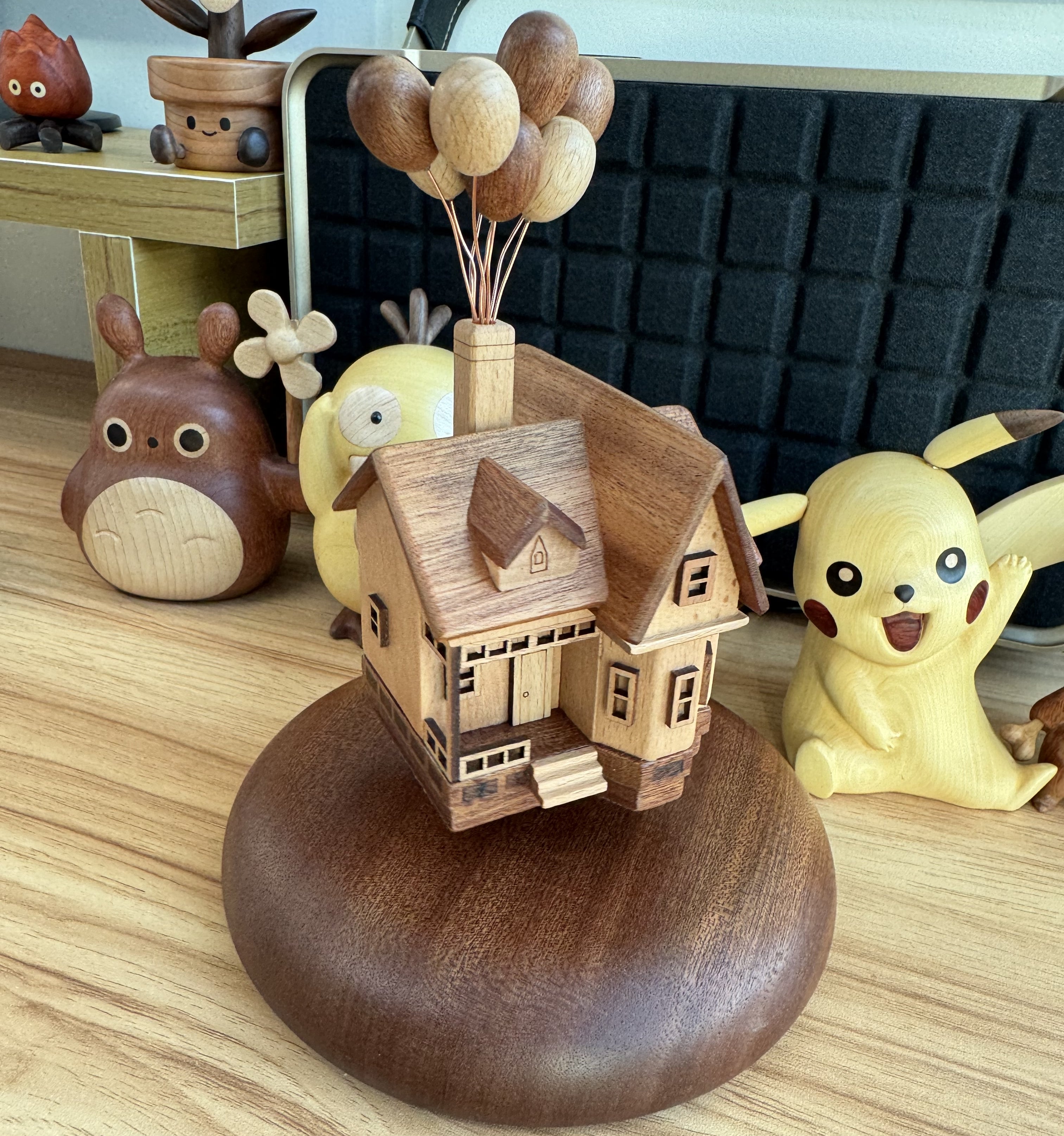Handmade wooden balloon house levitating on desk, floating toy creative gift.