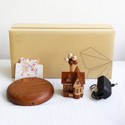 Unboxing view of the Levitating e wooden house gift set, including the magnetic base and power adapter.