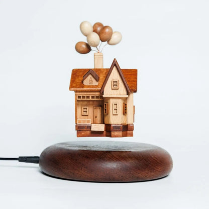 Main product shot of the handcrafted wooden balloon house floating above a magnetic walnut base.