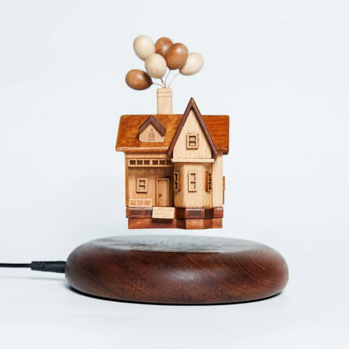 Main product shot of the handcrafted wooden balloon house floating above a magnetic walnut base.