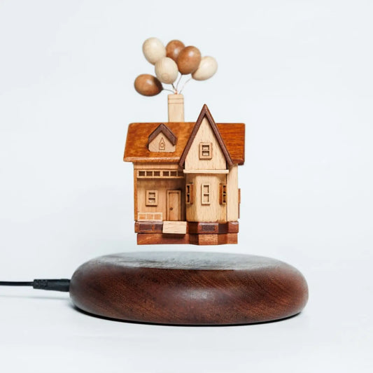 Main product shot of the handcrafted wooden balloon house floating above a magnetic walnut base.